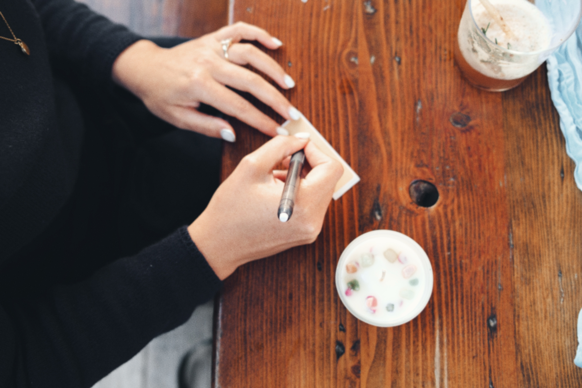 Hands writing at a wooden table